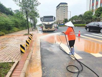 環(huán)衛(wèi)工人對春陽路路面進行沖洗作業(yè),助力恢復(fù)道路暢通。(周秀俊 攝)