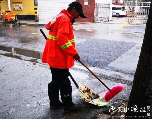 【清掃一科】環衛工人雨后清理積水落葉,確保道路干凈整潔 .